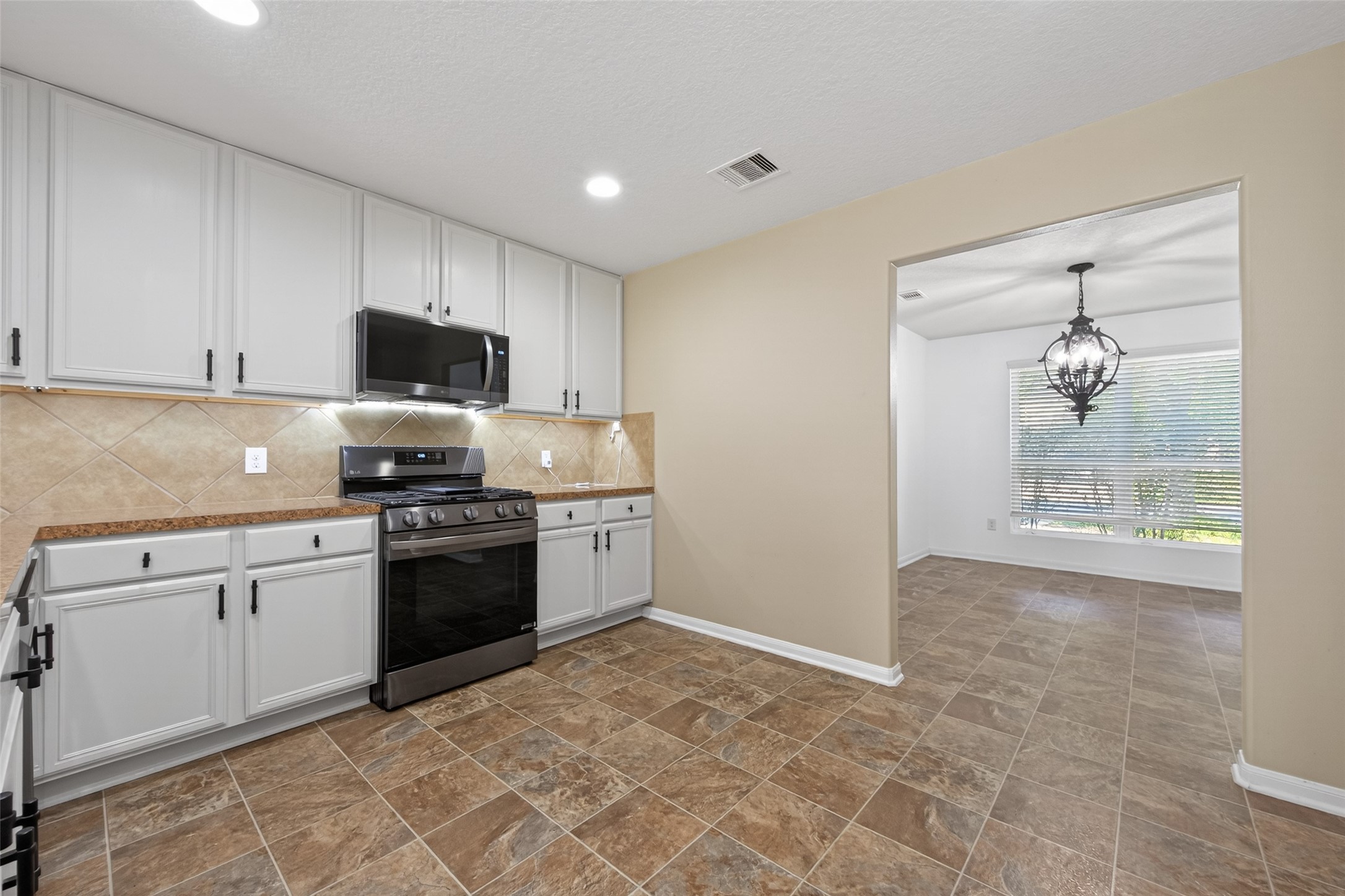 9940 Swallow Drive Conroe, TX 77385 - Photo 10 of 30 LG black stainless appliances purchased 2025. Upgraded 42” kitchen cabinets with motion LED under cabinet lighting