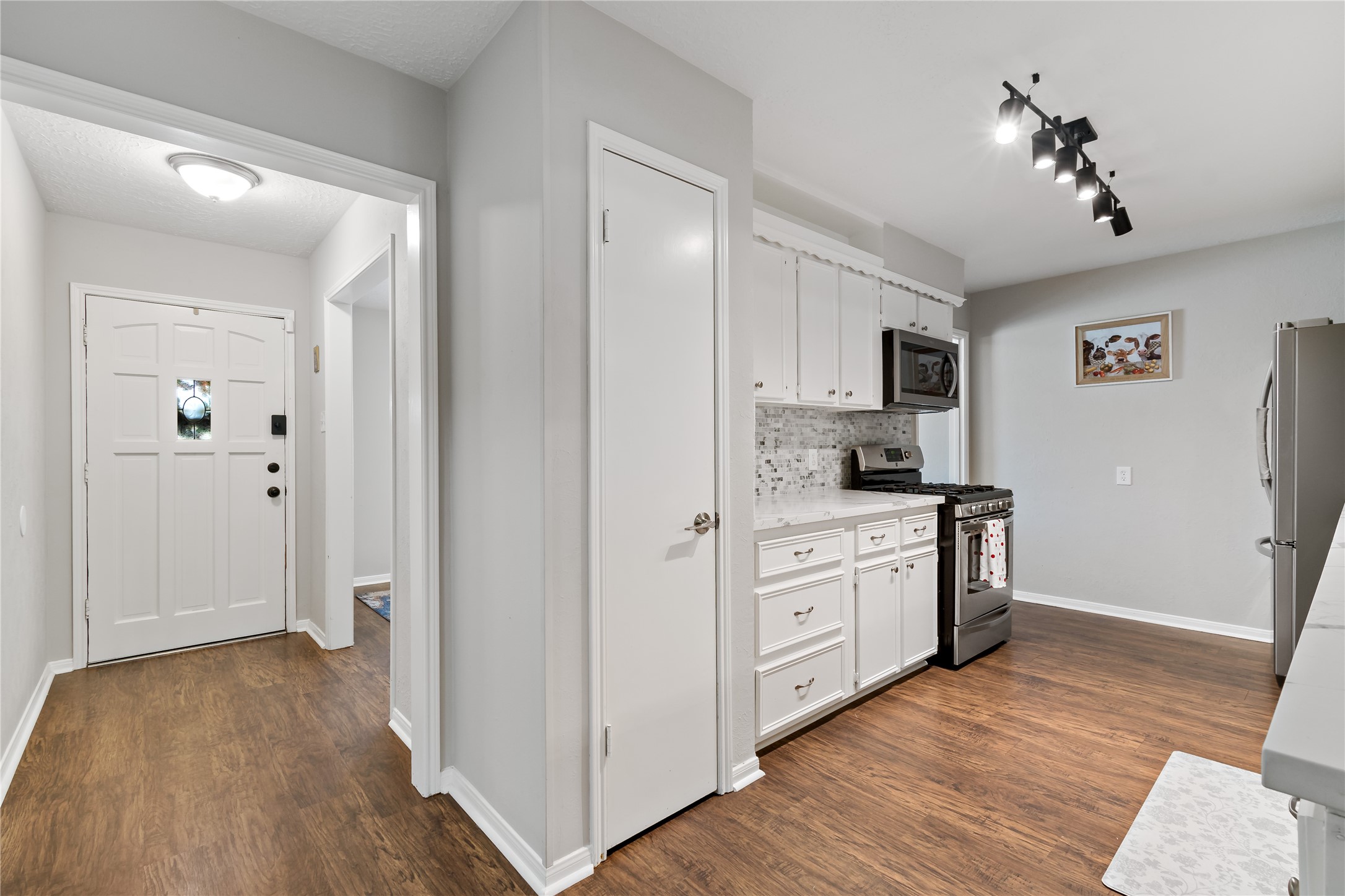 4302 Seneca Street Pasadena, TX 77504 - Photo 3 of 19 a kitchen with white cabinets and stainless steel appliances