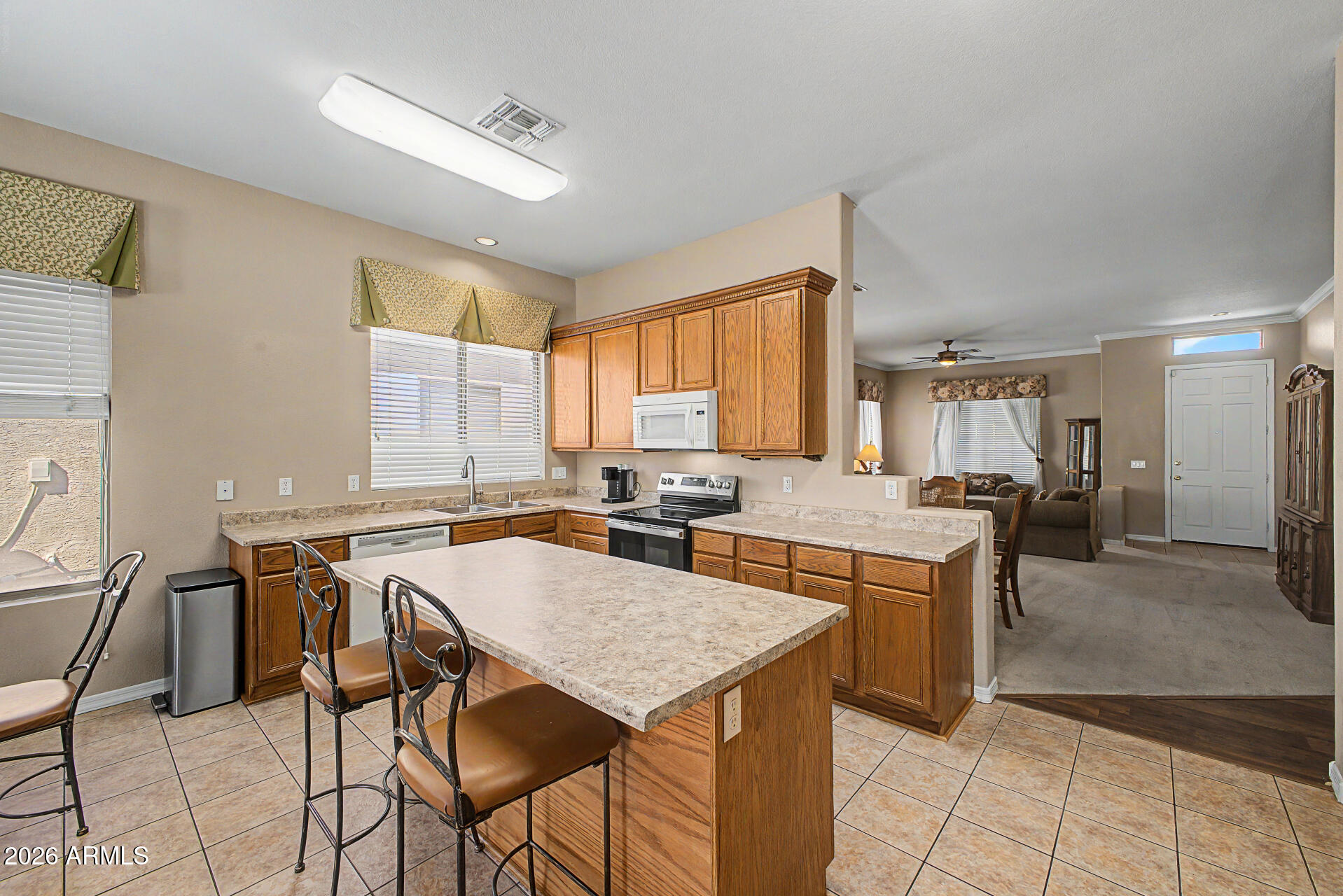 4394 South Strong Box Road Gold Canyon, AZ 85118 - Photo 12 of 33 a kitchen with a table chairs and a refrigerator