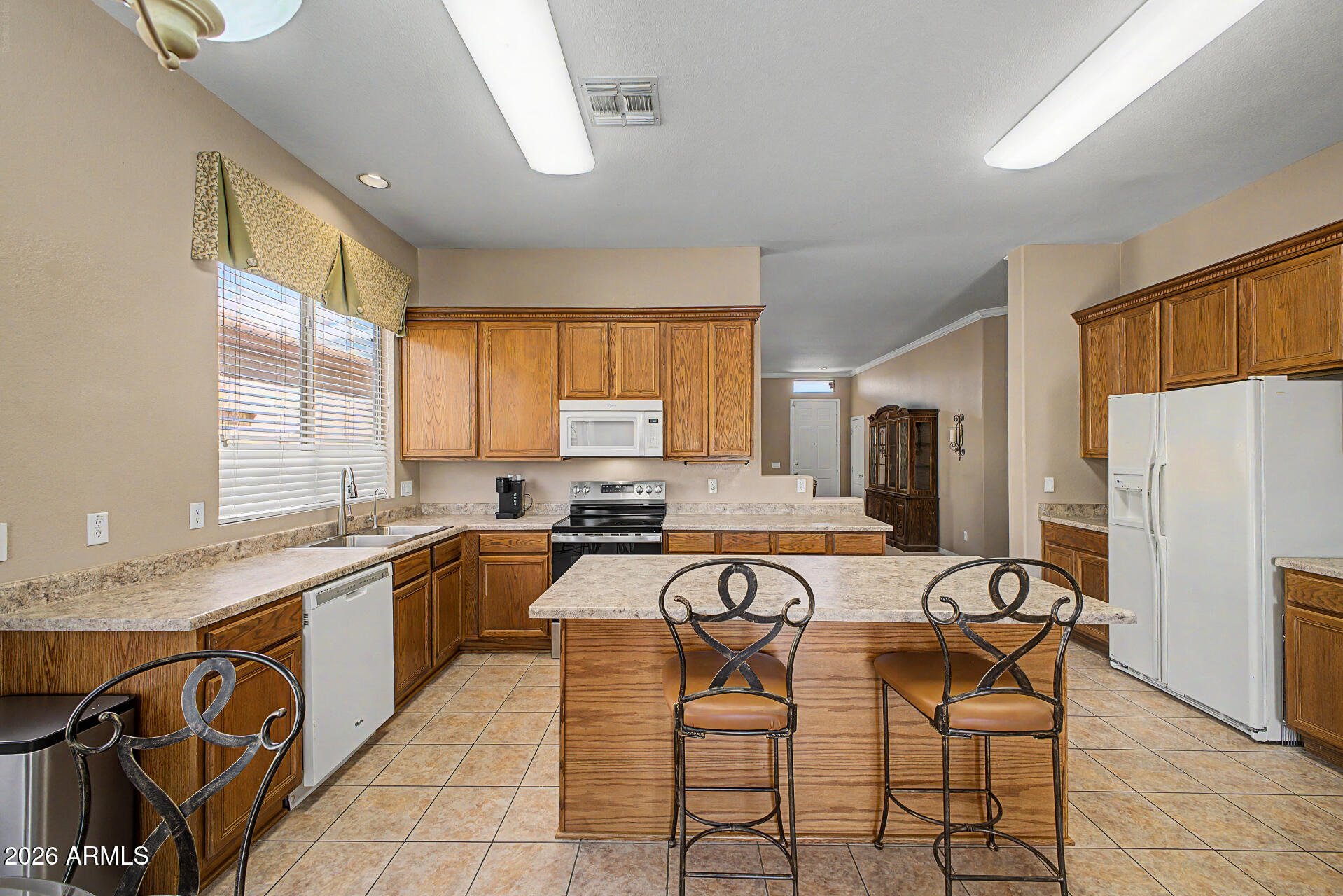 4394 South Strong Box Road Gold Canyon, AZ 85118 - Photo 13 of 33 a kitchen with stainless steel appliances granite countertop table chairs sink refrigerator and cabinets