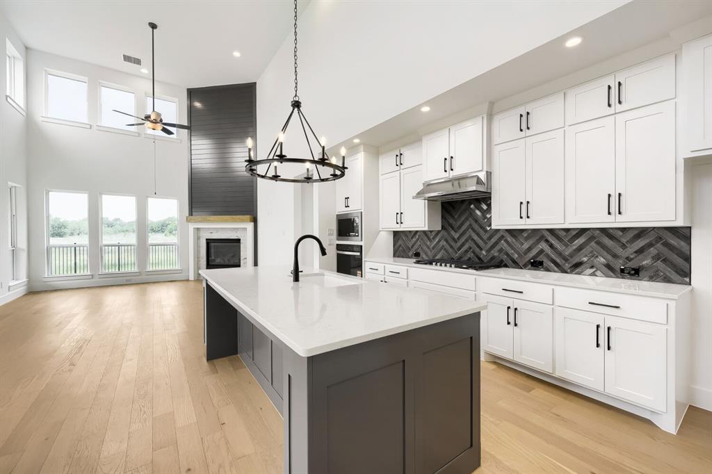 733 Red Cedar Road Haslet, TX 76052 - Photo 10 of 28 Open-concept living space featuring a modern kitchen island with a white countertop and dark cabinetry