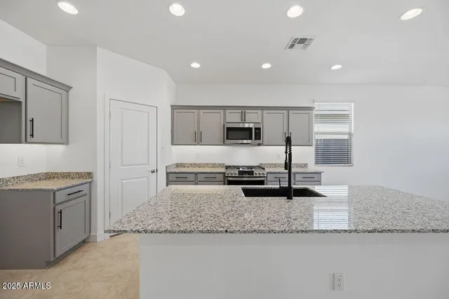 a kitchen with stainless steel appliances granite countertop a stove and a sink