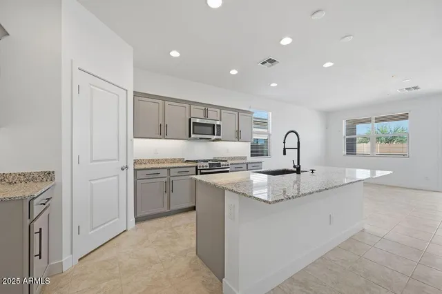 a kitchen with stainless steel appliances granite countertop a sink and a stove