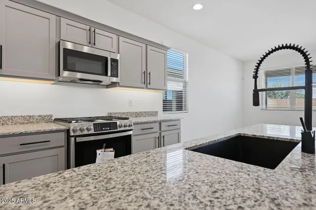 a kitchen with granite countertop a stove and a sink