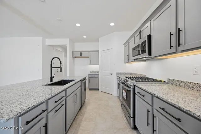 a kitchen with granite countertop a sink stove and cabinets