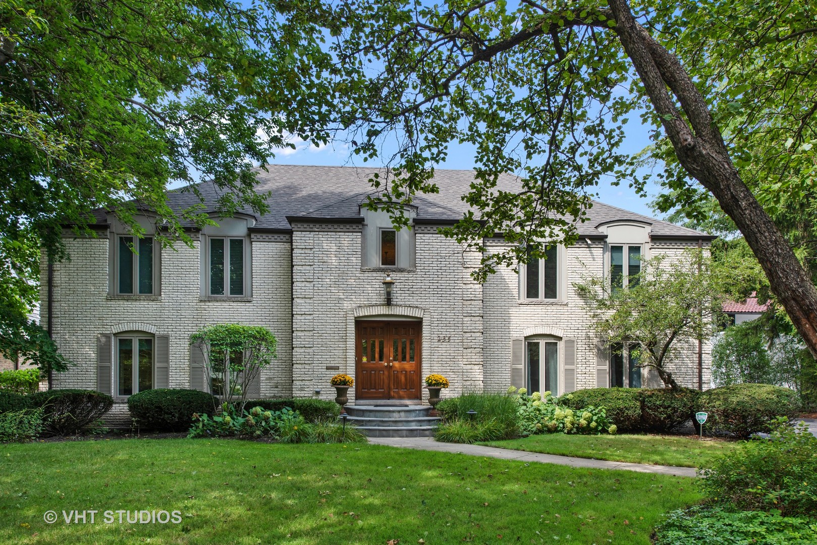 a front view of a house with a garden and plants