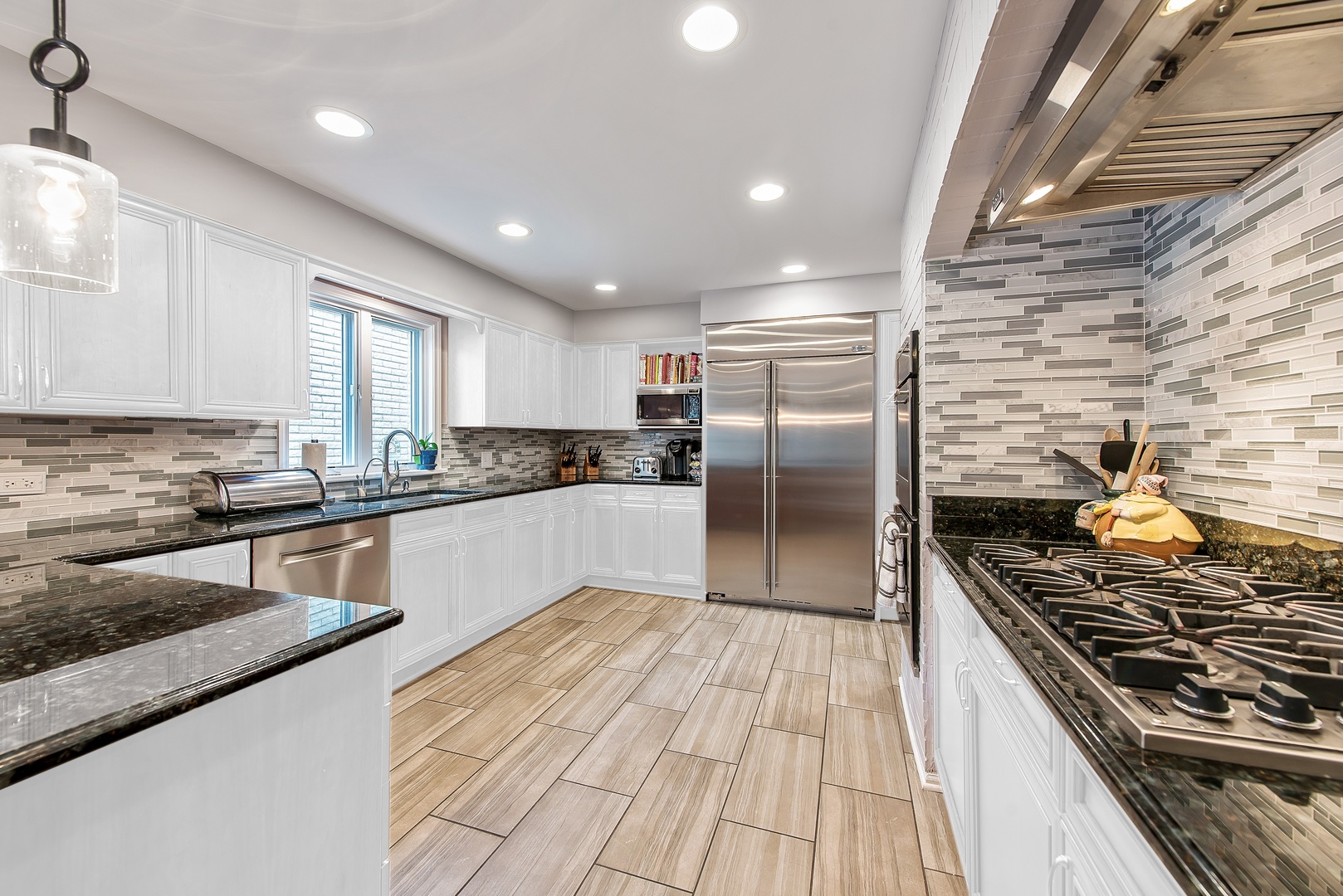 235 Maple Hill Road Glencoe, IL 60022 - Photo 6 of 35 a kitchen with stainless steel appliances granite countertop a stove a sink dishwasher a refrigerator and white cabinets with wooden floor