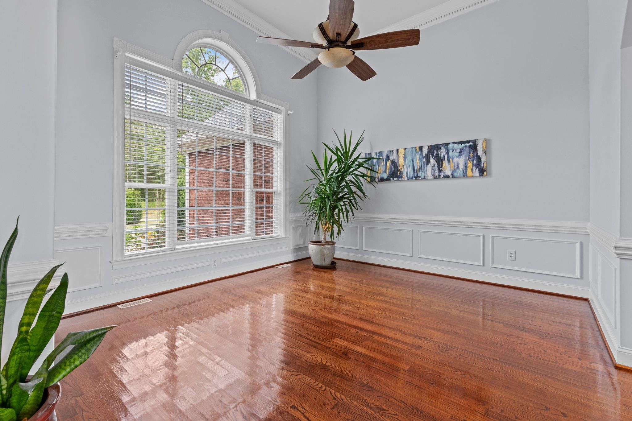 Gorgeous Dining Room with 10+ ft ceiling, ceiling fan, chair railing, hardwoof floors, and palladium window. Dining Room