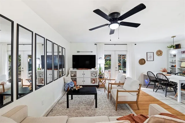 a living room with furniture a ceiling fan and a flat screen tv