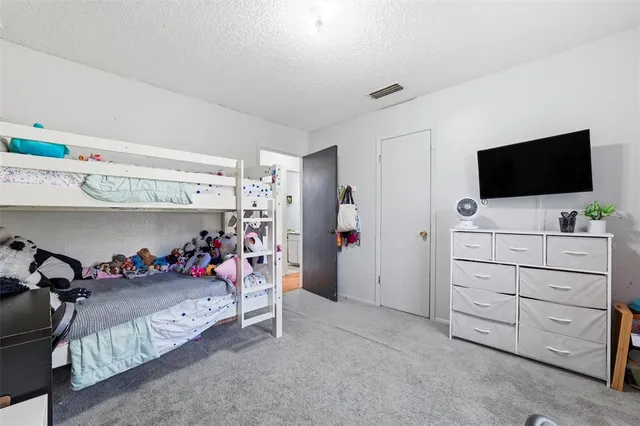 a bedroom with a bed and a flat tv screen on wall
