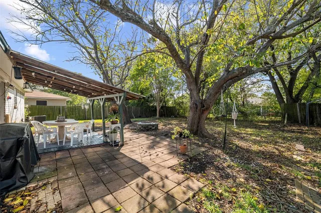 a view of a backyard with table and chairs under an umbrella