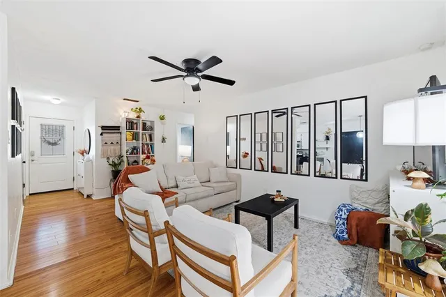 a living room with furniture a wooden floor and a ceiling fan