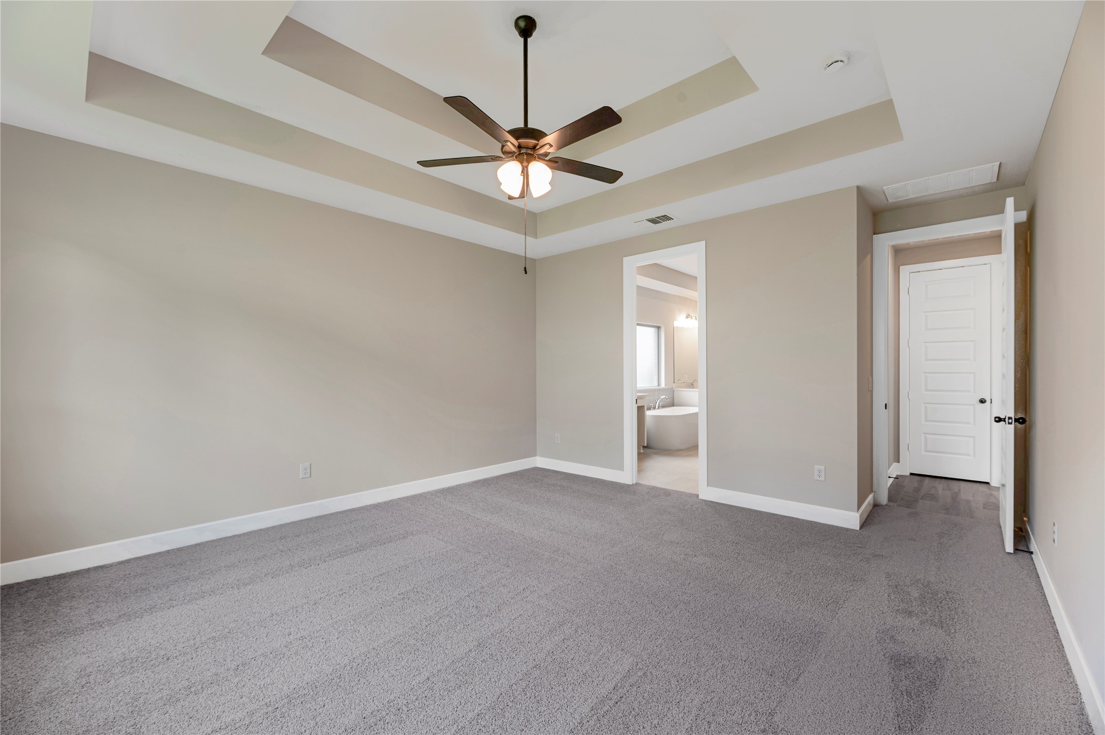 1508 Rodeo Ridge Drive Georgetown, TX 78628 - Photo 8 of 37 Unfurnished bedroom with a raised ceiling, light carpet, a ceiling fan, and ensuite bath