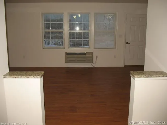 a view of a room with wooden floor and windows