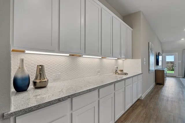 a kitchen with white cabinets and sink