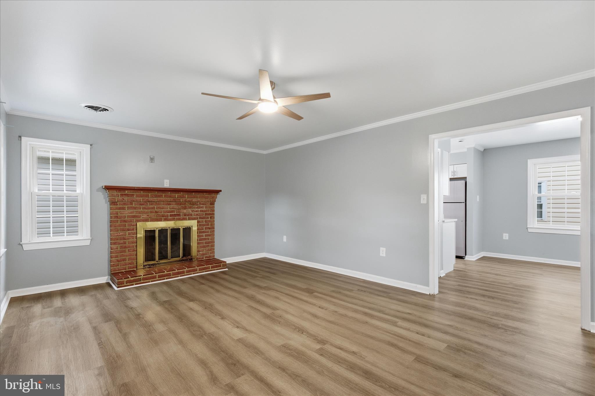 130 Cox Road Huntingtown, MD 20639 - Photo 3 of 41 an empty room with windows fireplace and wooden floor