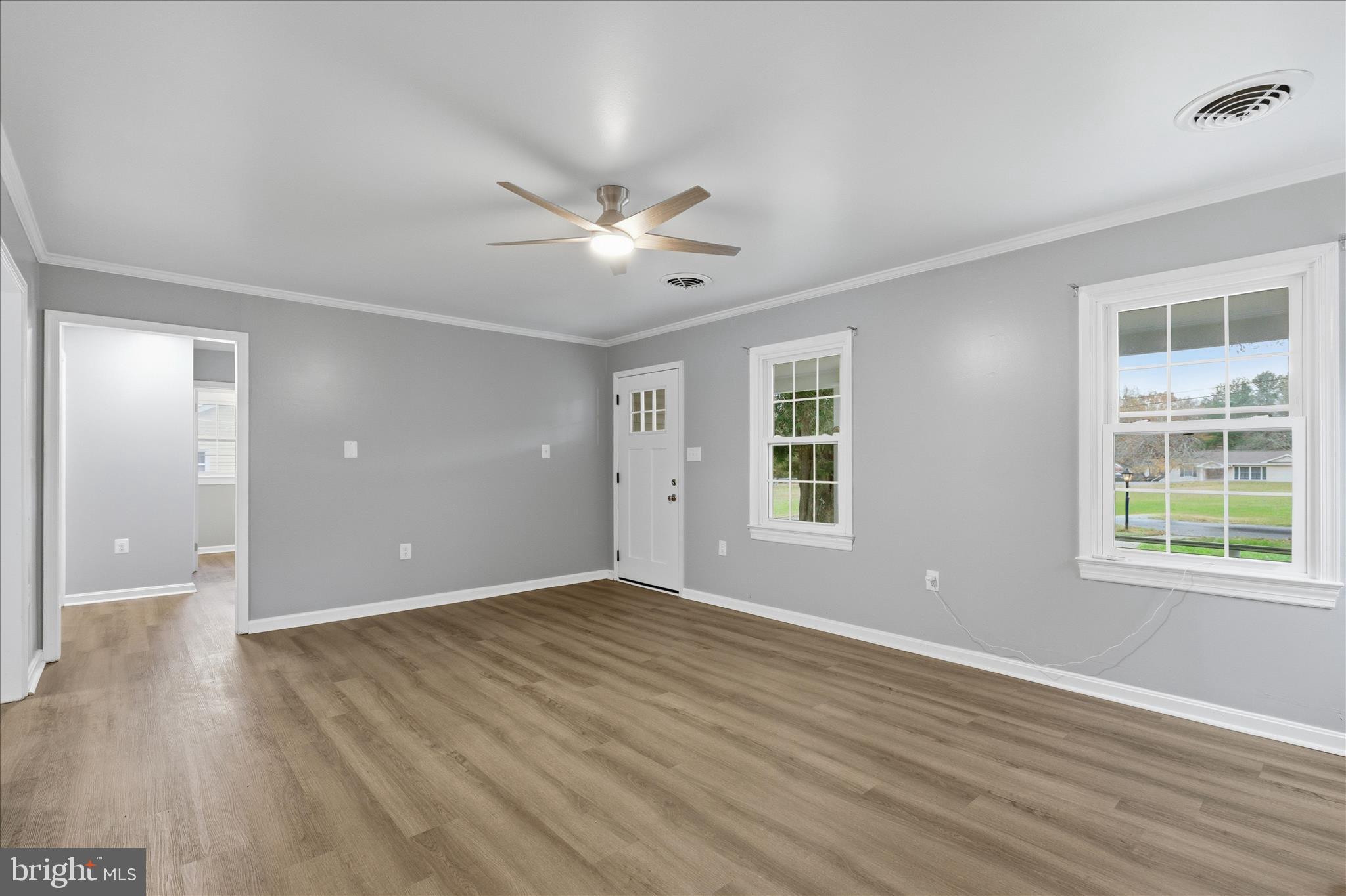 130 Cox Road Huntingtown, MD 20639 - Photo 4 of 41 a view of an empty room with a window and wooden floor