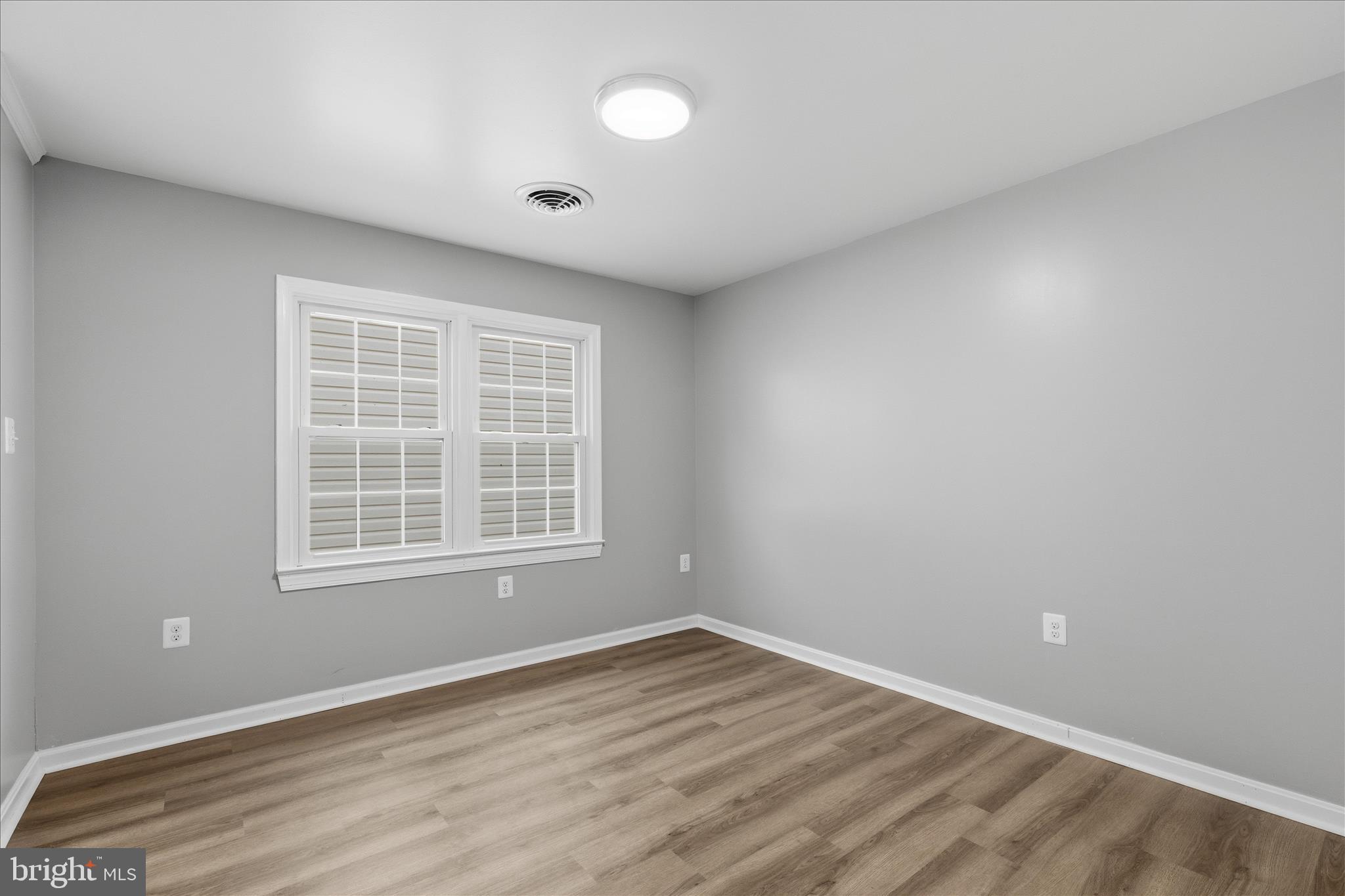 130 Cox Road Huntingtown, MD 20639 - Photo 7 of 41 an empty room with wooden floor and windows