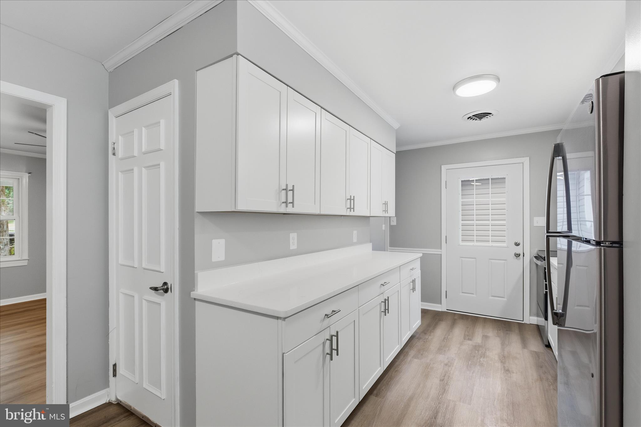 130 Cox Road Huntingtown, MD 20639 - Photo 9 of 41 a view of a kitchen with white cabinets and wooden floor