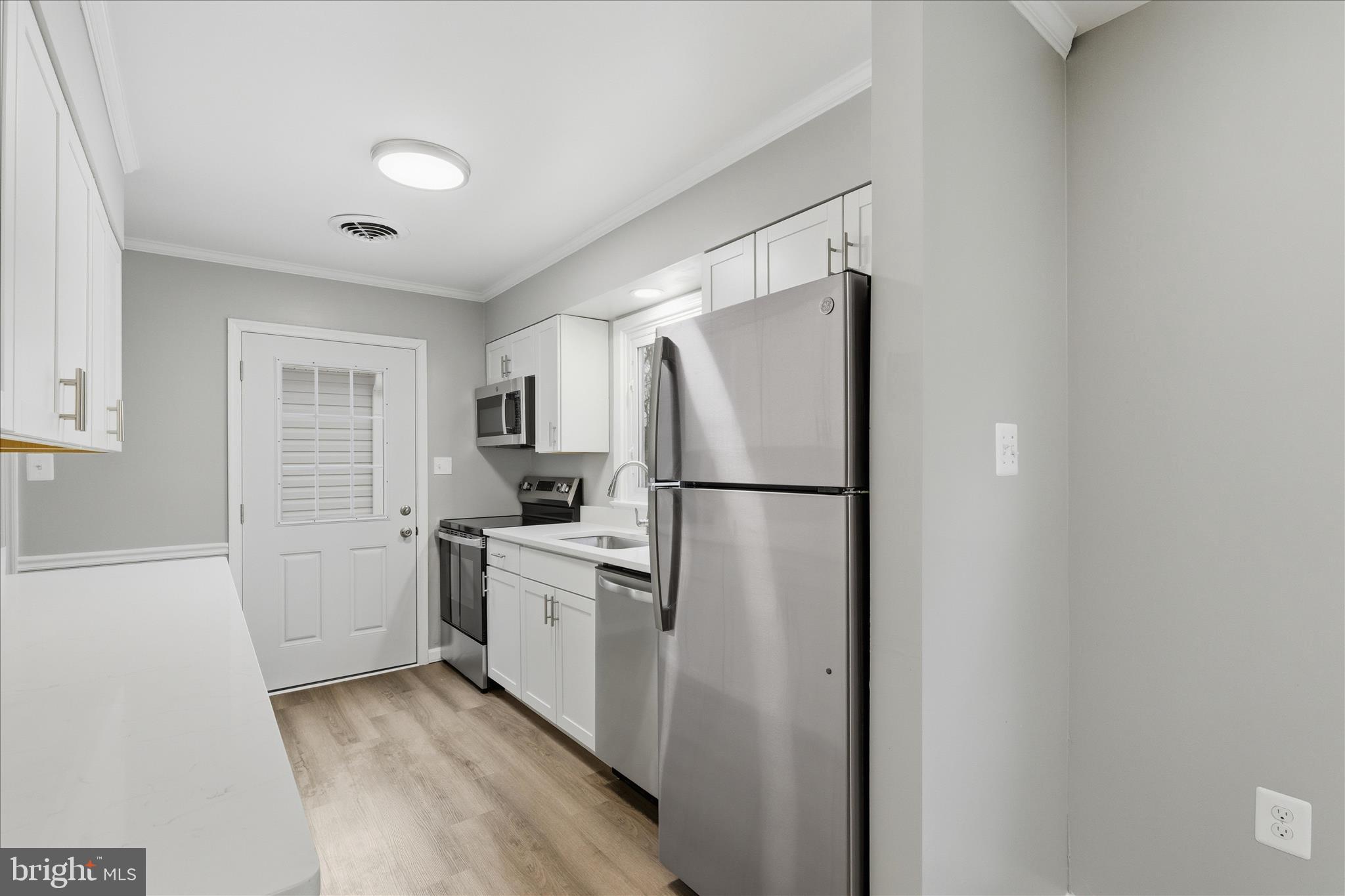 130 Cox Road Huntingtown, MD 20639 - Photo 10 of 41 a kitchen with white cabinets and stainless steel appliances