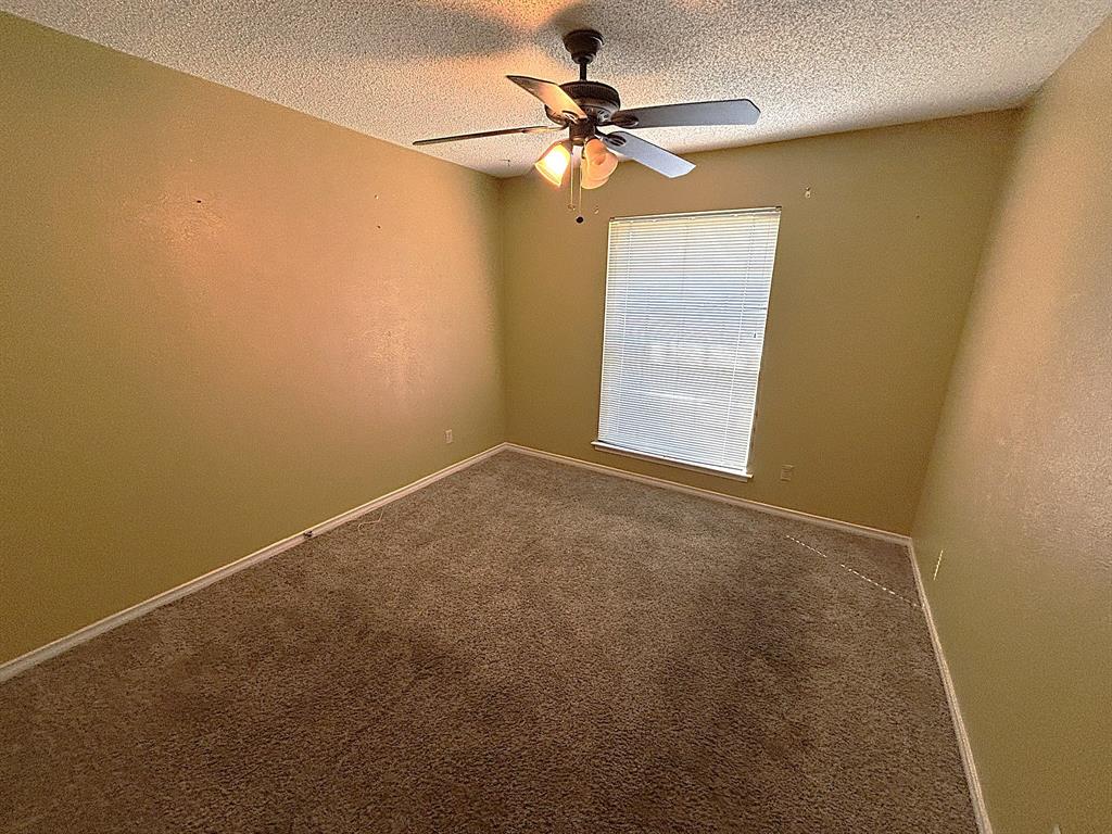 3042 Kiest Ridge Drive Dallas, TX 75233 - Photo 21 of 27 an empty room with a window and a fan