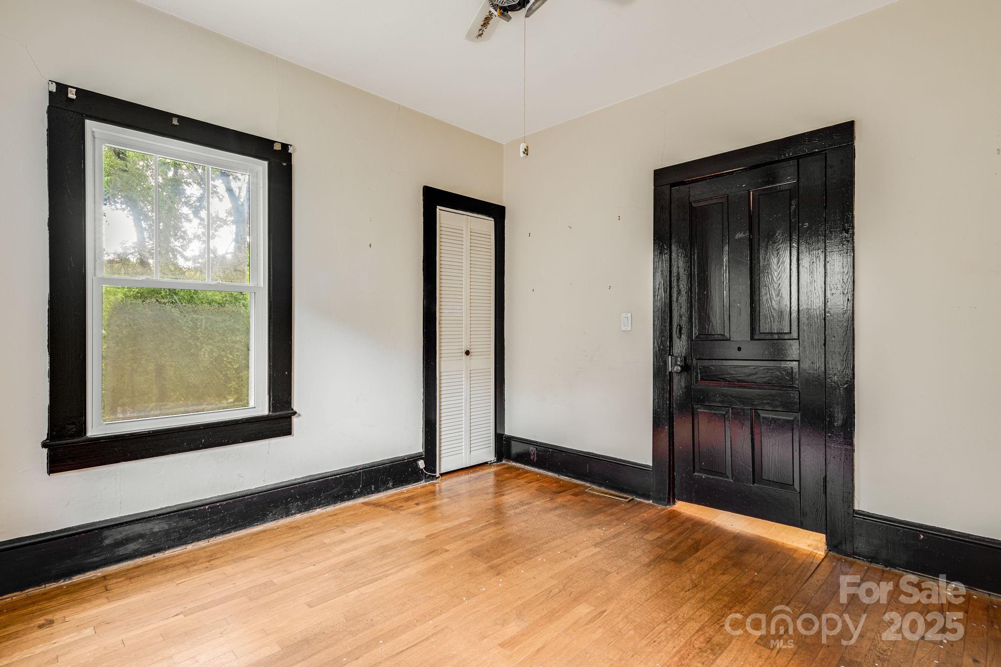 206 Rhododendron Drive Brevard, NC 28712 - Photo 22 of 36 a view of an empty room with wooden floor and a window