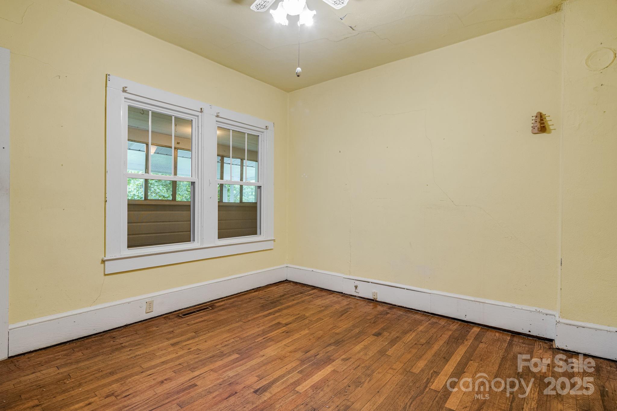 206 Rhododendron Drive Brevard, NC 28712 - Photo 24 of 36 a view of an empty room with wooden floor and a window