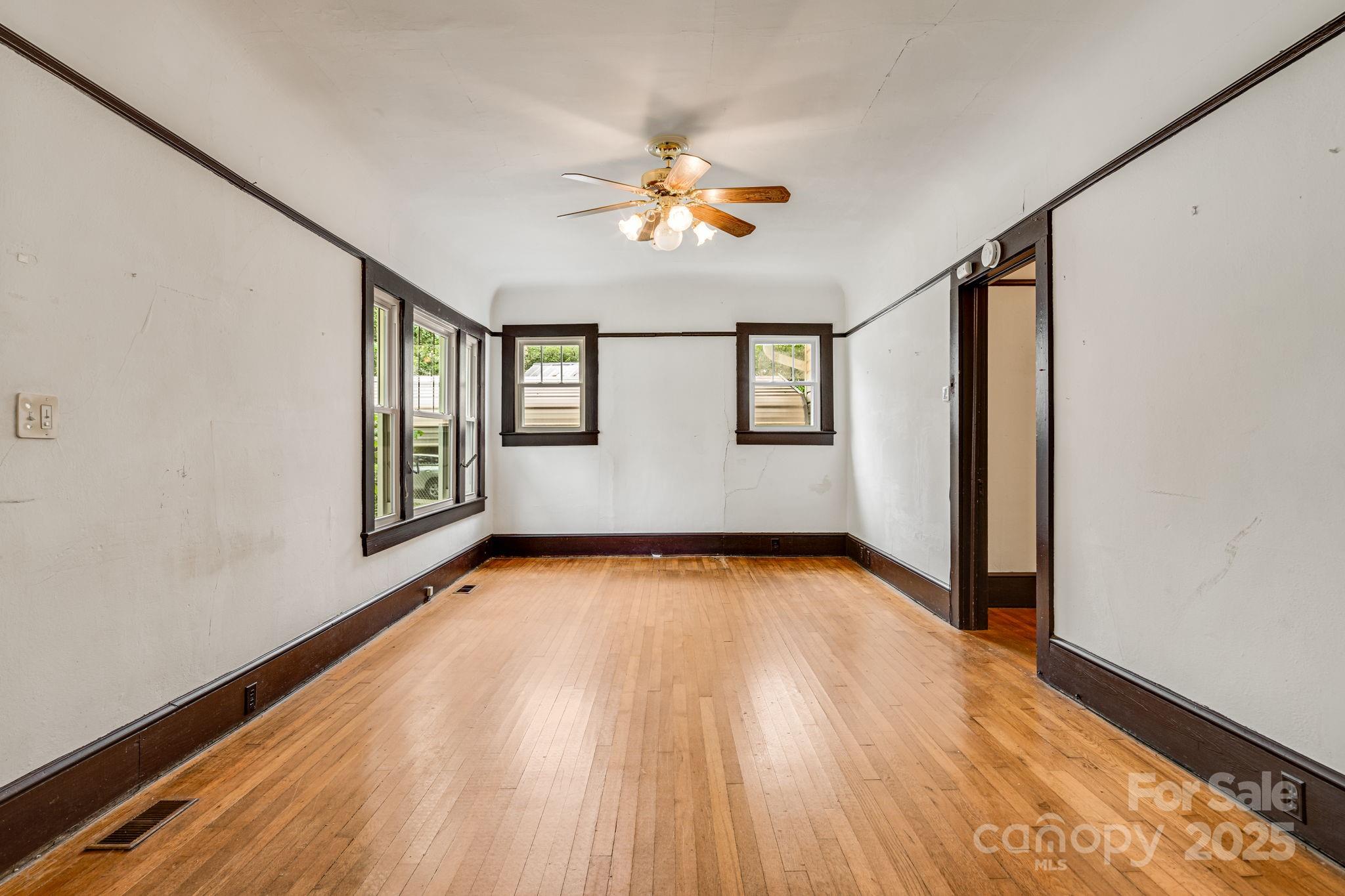 206 Rhododendron Drive Brevard, NC 28712 - Photo 9 of 36 a view of an empty room with window and wooden floor
