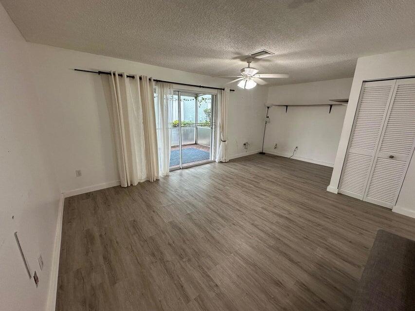 423 Waterside Circle Lake Worth, FL 33462 - Photo 12 of 21 wooden floor in an empty room with a window