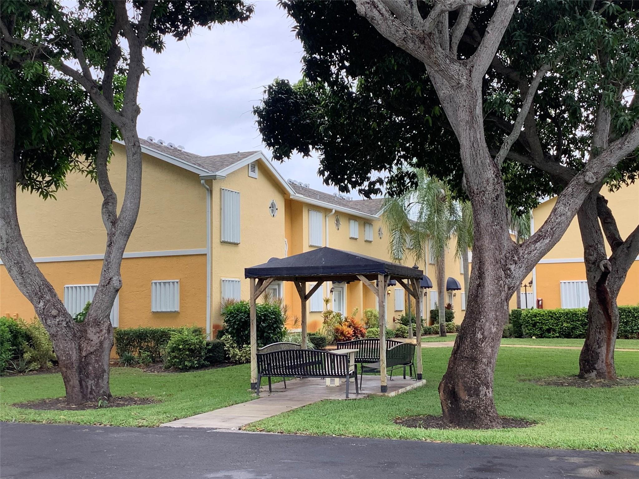 423 Waterside Circle Lake Worth, FL 33462 - Photo 2 of 21 a front view of a house with garden and trees