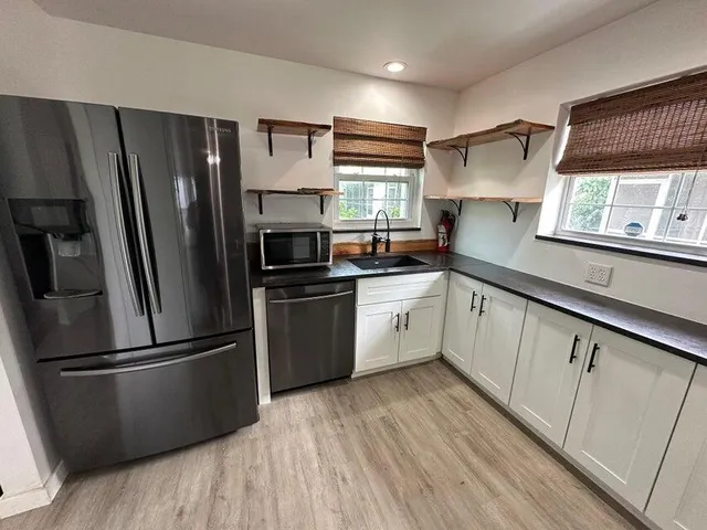 a kitchen with stainless steel appliances a refrigerator sink and cabinets