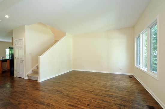 1132 Dell Road Northbrook, IL 60062 - Photo 3 of 20 a view of an empty room with wooden floor and a window