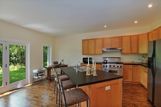 1132 Dell Road Northbrook, IL 60062 - Photo 7 of 20 a kitchen with stainless steel appliances granite countertop a stove top oven a sink dishwasher a dining table and chairs with wooden floor