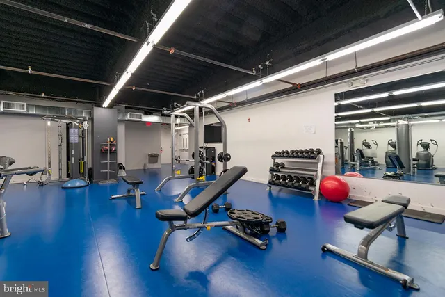 a room with gym equipment and wooden floor