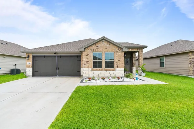 a front view of a house with a yard and garage