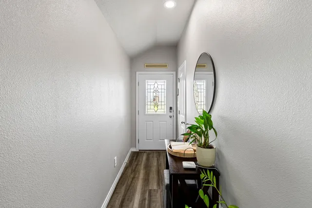 a view of a hallway with wooden floor and a potted plant