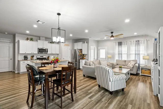 a dining room with furniture a chandelier and wooden floor