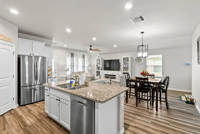 a kitchen with sink a counter and chairs