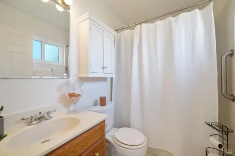 a bathroom with a sink a toilet and shower curtain