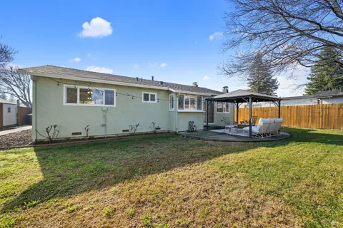 a backyard of a house with barbeque oven table and chairs