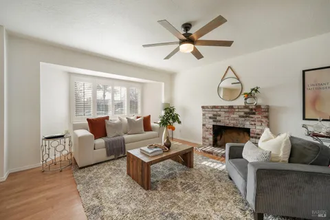 a living room with furniture a clock and a fireplace