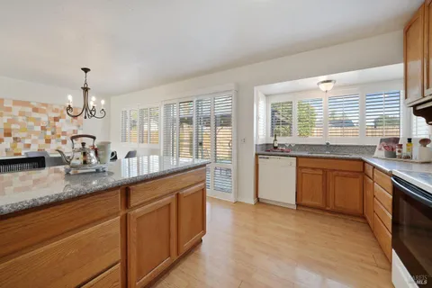 a kitchen with stainless steel appliances granite countertop a sink stove and cabinets