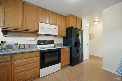 a kitchen with granite countertop wooden cabinets and stainless steel appliances