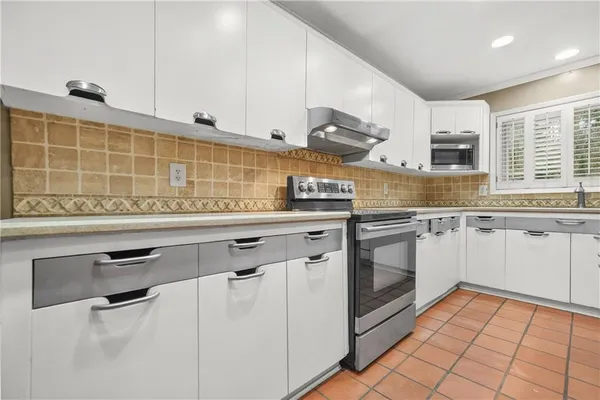a kitchen with windows and refrigerator