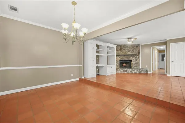 a view of an empty room with kitchen and window