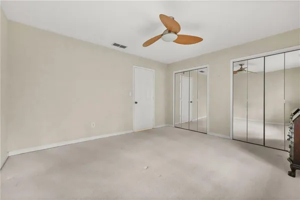 an empty room with a ceiling fan and a window