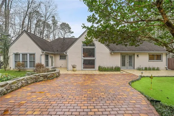 a front view of a house with a garden and trees