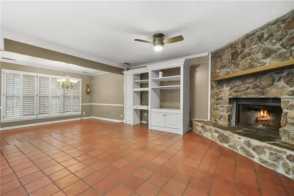 an empty room with windows and fireplace