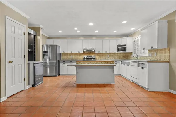 a kitchen with stainless steel appliances granite countertop a stove a sink and a microwave