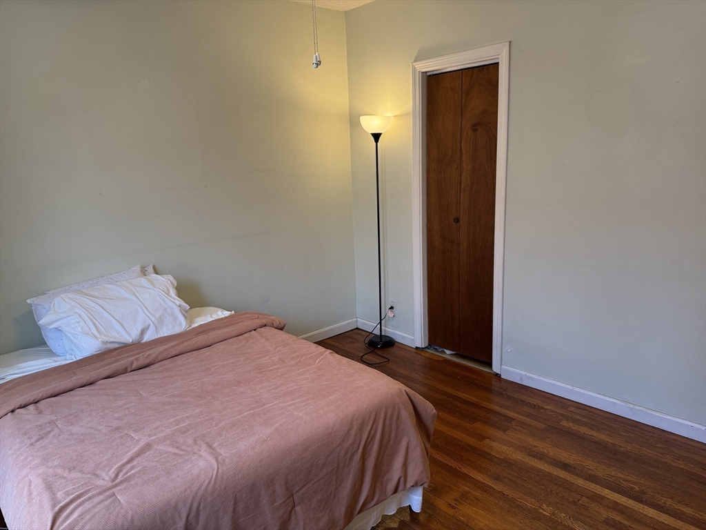 313 Summit Avenue, Unit 5 Boston, MA 02135 - Photo 5 of 13 a bedroom with a bed and wooden floor